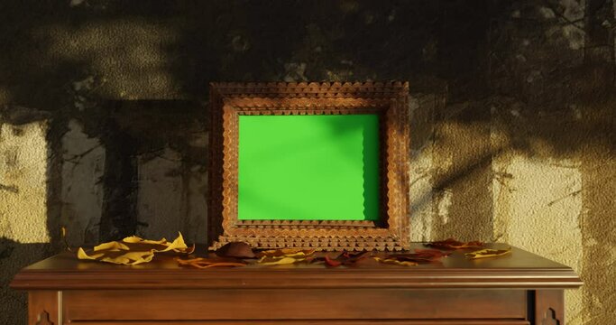 Aged picture frame with green screen standing on wooden commode. Shaded by windy tree and falling leaves