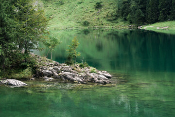 Seealpsee mountain lake reflection in Alpstein mountain range during summer at Appenzell, Switzerland