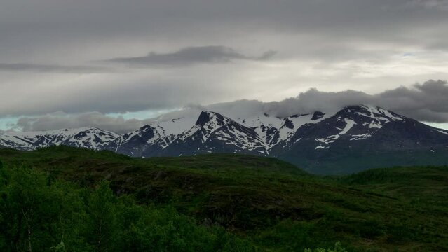 Timelapse of clouds moving over snowy mountains. Filmed in northern Norway.