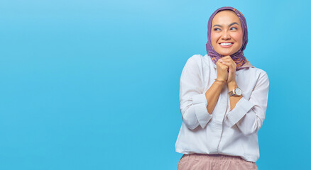 Portrait of happy young Asian woman looking cheerfully aside wit