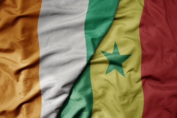 big waving national colorful flag of cote divoire and national flag of senegal .