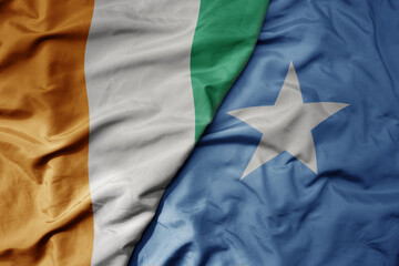 big waving national colorful flag of cote divoire and national flag of somalia .