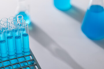 Close up of laboratory test tubes with blue liquid and copy space on white background