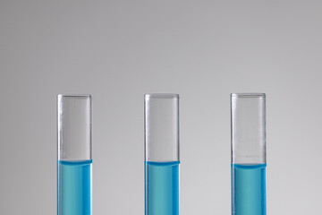 Close up of laboratory test tubes with blue liquid and copy space on white background
