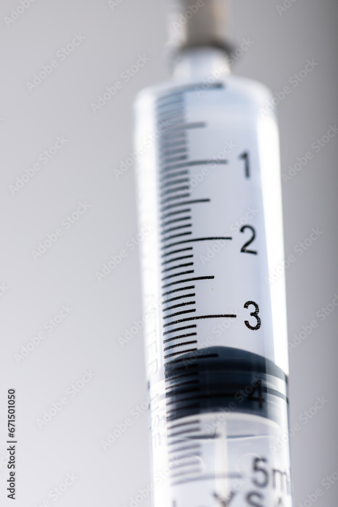 Poster vertical image of close up of laboratory syringe and copy space on grey background