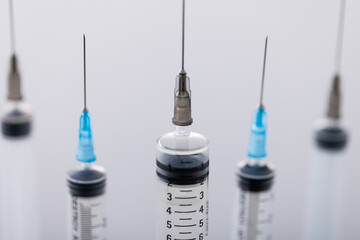 Close up of laboratory syringes with needles and copy space on white background