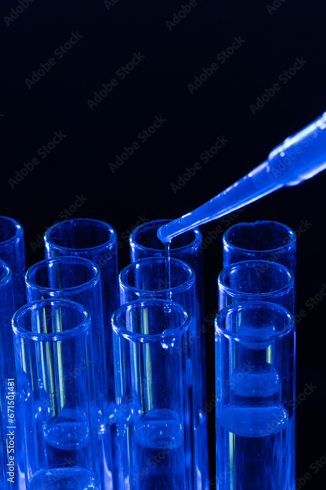 Aufkleber vertical image of close up of laboratory test tubes and pipette with copy space on black background