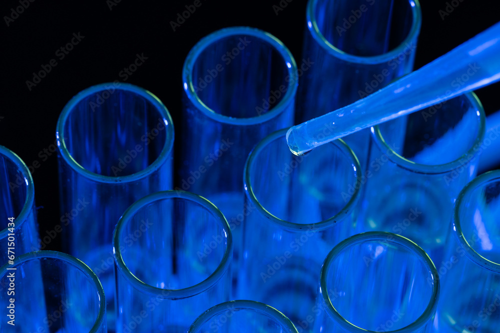 Poster close up of laboratory test tubes and pipette with copy space on blue background