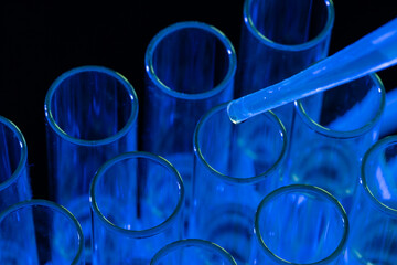 Close up of laboratory test tubes and pipette with copy space on blue background