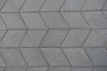Surface of gray diamond shaped concrete pavement with geometric pattern