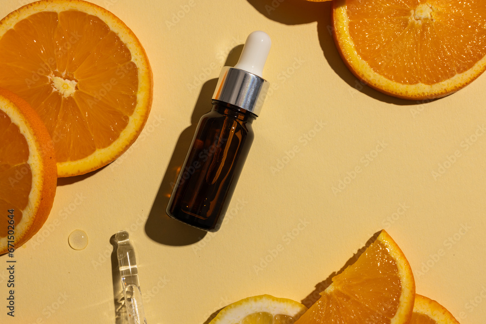 Poster bottle with pipette and oranges with copy space on yellow background