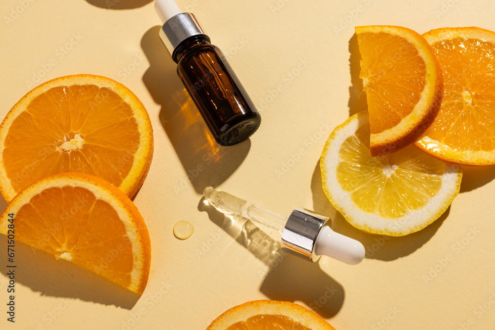 Poster bottle with pipette and oranges with copy space on yellow background