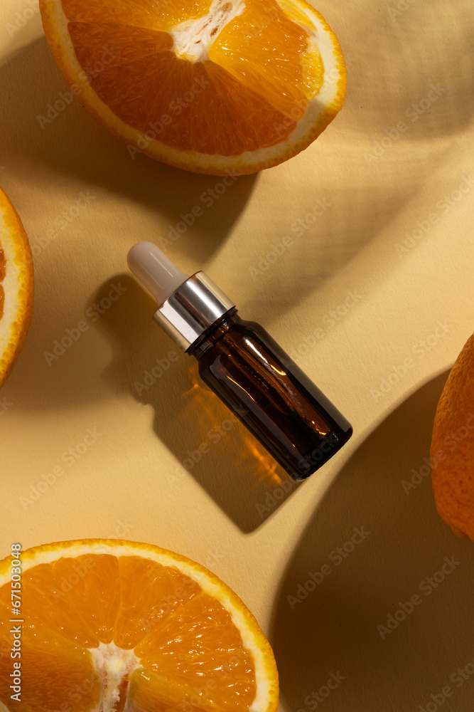 Poster close up of bottle with pipette and oranges and copy space on orange background