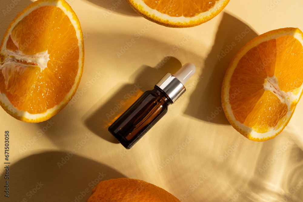 Poster close up of bottle with pipette and oranges with copy space on yellow background