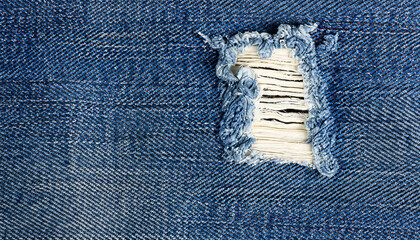 Blue jeans with a white stripe that has been torn off, Destroyed torn denim blue jeans texture, close-up rip in blue denim fabric, revealing white fabric underneath - obrazy, fototapety, plakaty