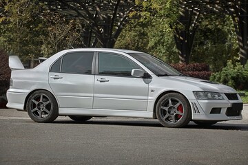 White car on a street background. Modern city sport car with a spoiler wallpaper