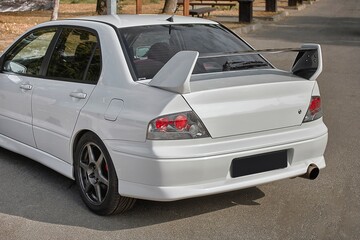 White car on a street background. Modern city sport car with a spoiler wallpaper