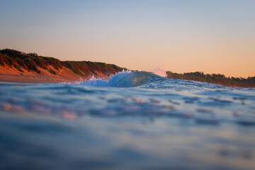 A small barrel wave in the ocean shore.