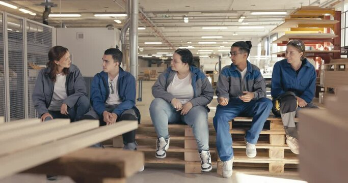 Fellow carpentry apprentices sitting on pallet in the wood workshop