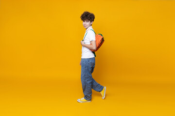 Fototapeta na wymiar Curly teenager with a briefcase, on a yellow background.