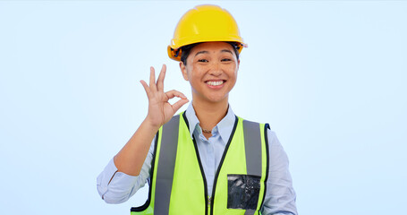 Woman, okay and hands in smile by engineer for construction by architect in studio by blue background. Asian female, development or success for real estate, inspection and yes sign or emoji in mockup
