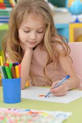 Portrait of cute girl drawing picture at home