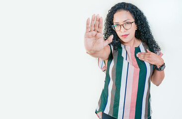 Young afro woman rejecting with the palm hand isolated. Afro girl gesturing stop isolated. Latin...