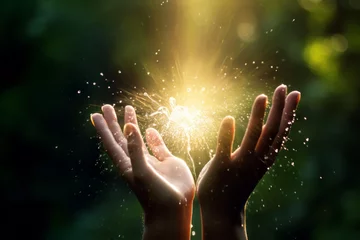 A dazzling light filled with happiness, hope, and love radiates from the woman's palm. It symbolizes the growth of living life freely and achieving the ideal. Concept for lifestyle and self-growth. © omune