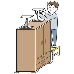 家具に転倒防止グッズを取り付ける男性