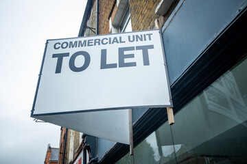 Estate agent commercial property shop To Let sign on high street shop