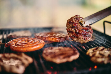 Delicious meat on the grill, making barbecue outdoors. - obrazy, fototapety, plakaty