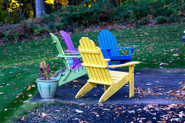 Adirondack chairs sit on a patio in Autumn in Hershey PA. Purple and Blue Chairs look inviting this...