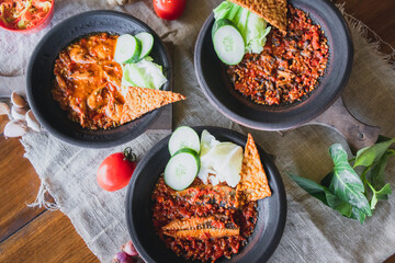 Hot plate or Sambal Gami is Traditional food from Indonesia. Served on plate with a bowl of rice and vegetables top view. Super hot and spicy food