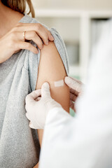 Covid, vaccine and injection with a doctor placing a plaster on the arm of a female patient in the...