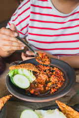 Hot plate or Sambal Gami is Traditional food from Indonesia. Served on plate with a bowl of rice and vegetables top view. Super hot and spicy food