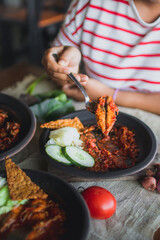 Hot plate or Sambal Gami is Traditional food from Indonesia. Served on plate with a bowl of rice and vegetables top view. Super hot and spicy food