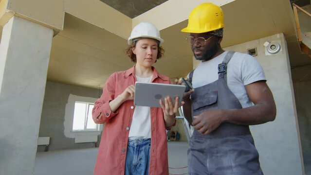 Multi-ethnic builders discussing construction project plan