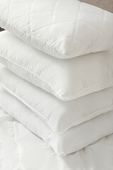 Different types of white bed pillows on a white bed. Pillow menu. Cushions. Home textile