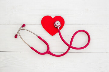 Cardiology and insurance concept with red heart and medical stethoscope