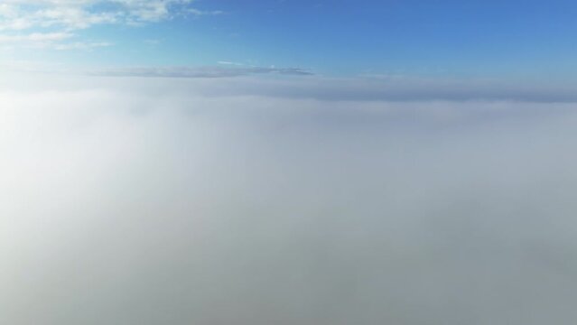 Beautiful sky above the low clouds with sunlight over the fluffy clouds. Flying Drone view.