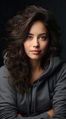 Naklejka premium Portrait of a young latin woman with pleasant smile and crossed arms on grey wall with copy space. Beautiful girl with folded arms looking at camera against grey wall. Generative AI art