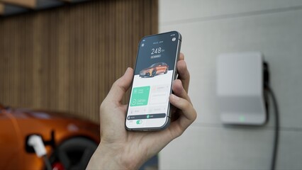 CU Caucasian man using EV application on his phone to check charging status 