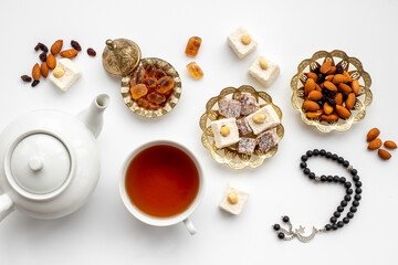 Muslim holiday concept - tea cups and Muslim rosary with a crescent moon