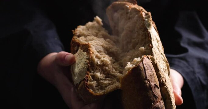 Hands breaking freshly baked bread