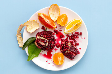 Splash juicy pomegranate and citrus fruits layout, top view