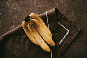 Close-up of a bunch of bananas on a brown textured background