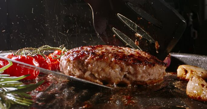 Chef takes frying beef halal cutlet and turns around using kitchen spatulas on pan preparing Burger. Cinematic advertising burger cooking. Keto dieter's dream, mouthwatering, low-carb cutlets. 