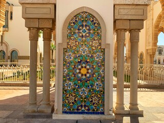 exterior of colorful tiles on wall of The Hassan II Mosque or Grande Mosquée Hassan II is a mosque...