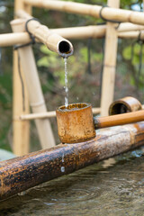 Close up shot of purification fountain with bamboo and wooden scoop in Japan