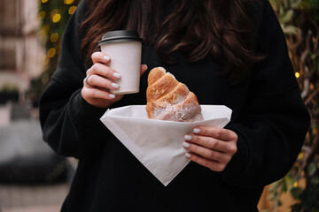 girl holding croissants and coffee